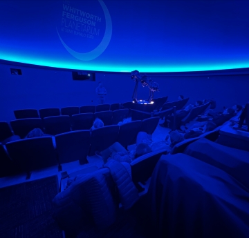 Blue shaded planetarium with rows of seats